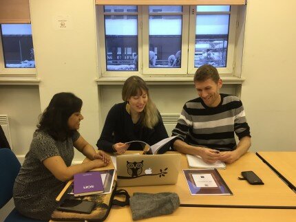 Three ESRs working as a group around a table during the workshop